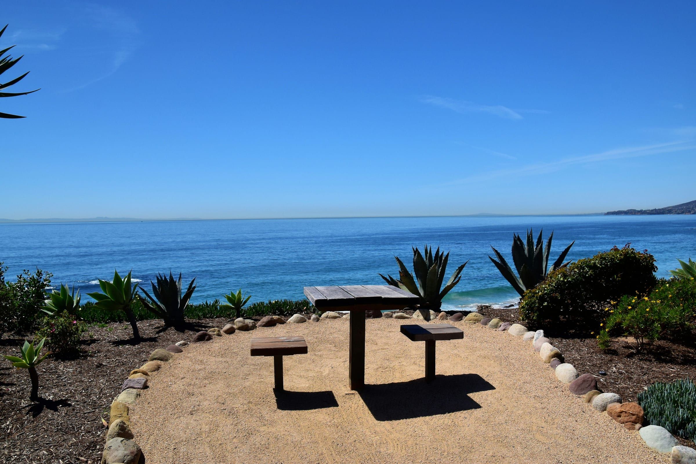 A picnic table in a garden above the ocean in Laguna Beach