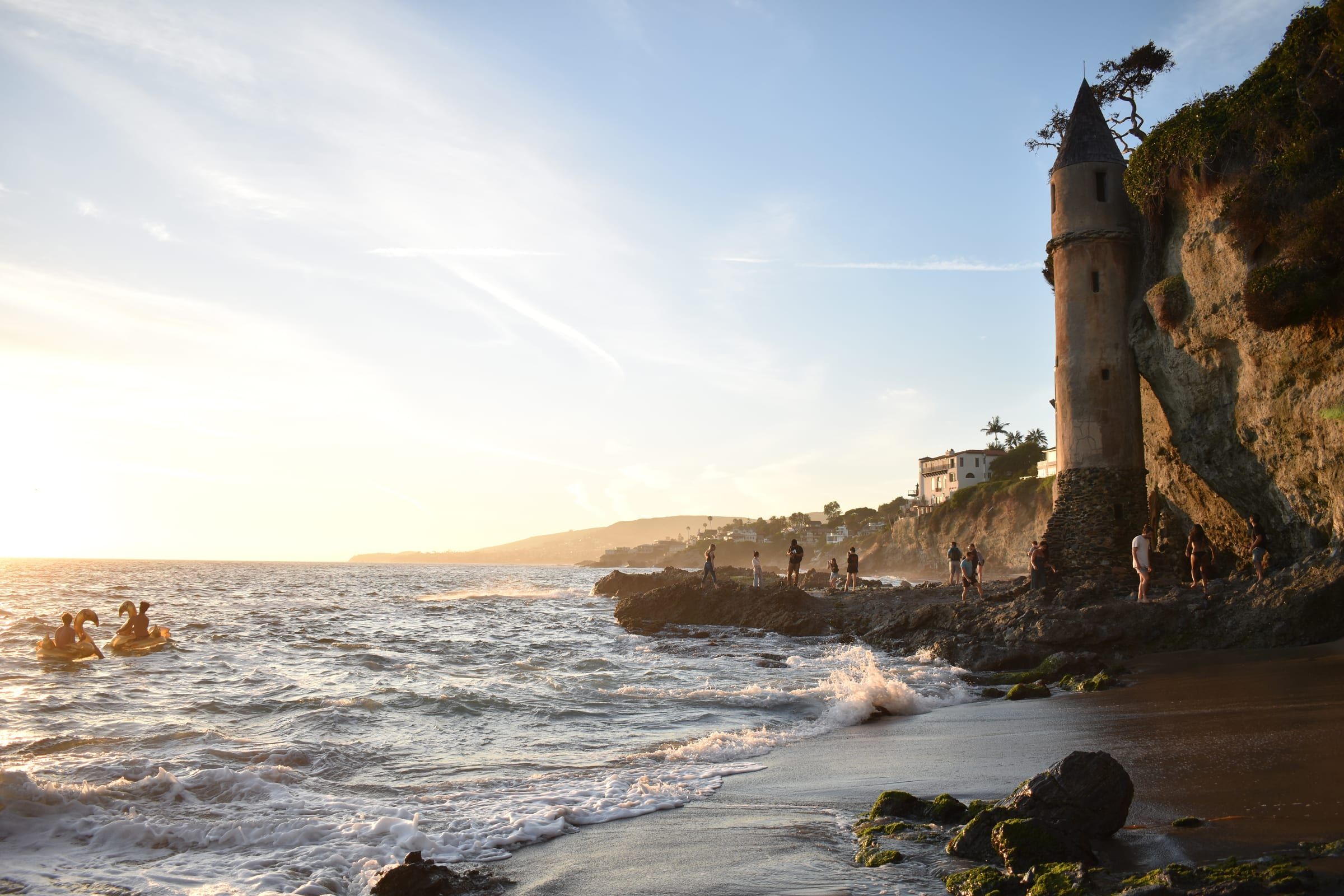 The Pirate Tower rising from the bluff above Victoria Beach in Laguna Beach, with waves on the sand
