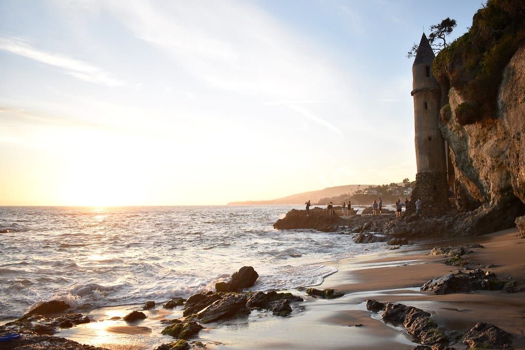Sunset over the waves and sand at Victoria Beach with the Pirate Tower on the bluff