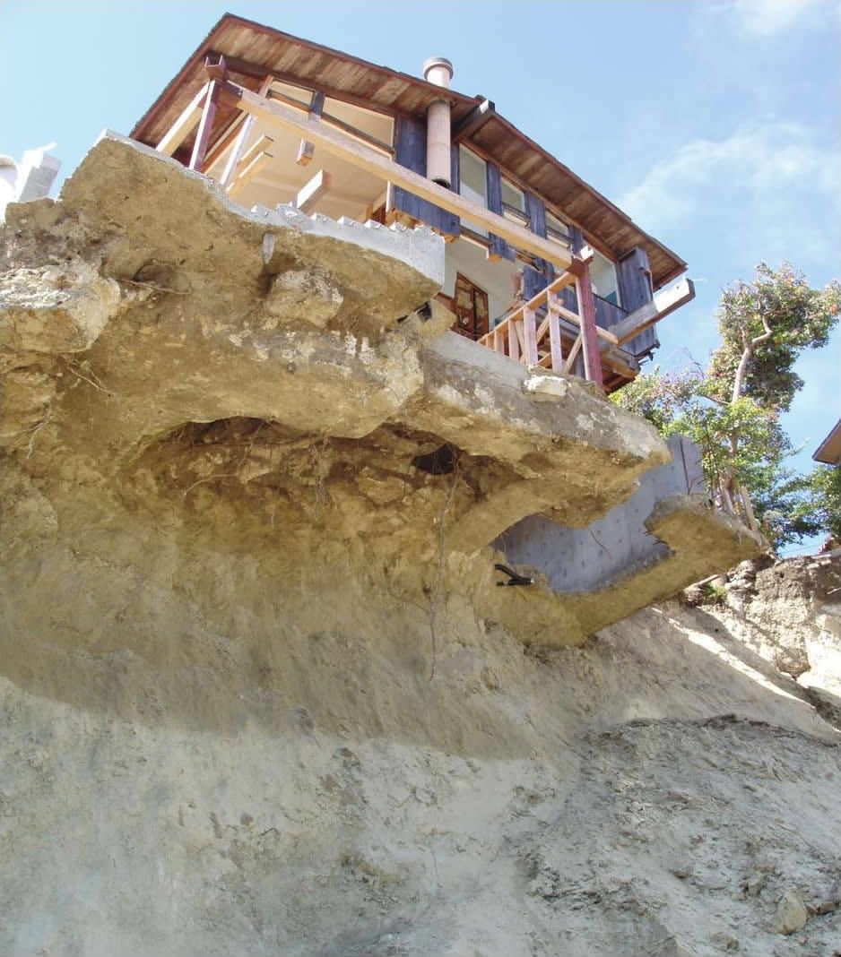 A house left at the edge of a cliff of exposed earth after the 2005 Laguna Beach landslide